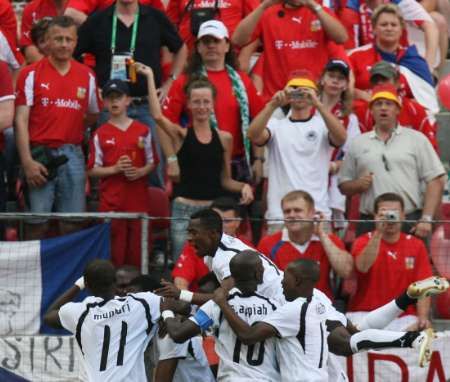 Fotbalisté Ghany se radují z gólu před sektorem zaskočených českých fanoušků. | Foto: Reuters