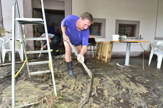 V Děčíně se v neděli ráno sešla povodňová komise, začalo se uklízet a sčítat škody. "Máme poničené silnice, chodníky, silnice na Žleb je zavalená kameny, tam bude potřeba těžká technika na odstranění. Vytopenou máme budovu magistrátu A3, hasiči to jdou vyčistit, bylo tam asi pět centimetrů bláta. V části Bělá ještě stále teče voda po silnici a zůstaly tam laguny," řekl ČTK mluvčí magistrátu Luděk Stínil. | Foto: ČTK