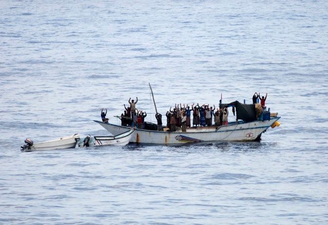 Piráti a rukojmí zvedají ruce předtím, než na palubu lodi vstoupí nizozemské komando | Foto: Reuters