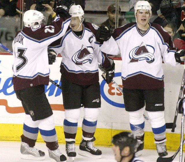 Joe Sakic (uprostřed) přijímá od svých spoluhráčů z Colorada Milana Hejduka (vlevo) a Paula Stastneho gratulace k 600. gólu v NHL. | Foto: Reuters