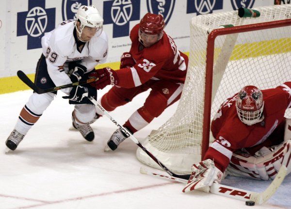 Dominik Hašek v bráně a kapitán Detroitu Kris Draper brání v střeleckém pokusu edmontonského centra Sama Gagnera. | Foto: Reuters