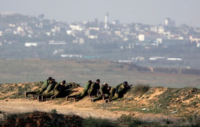 Izraelští vojácí vyhlížejí ze svých pozic pásmo Gazy | Foto: Reuters