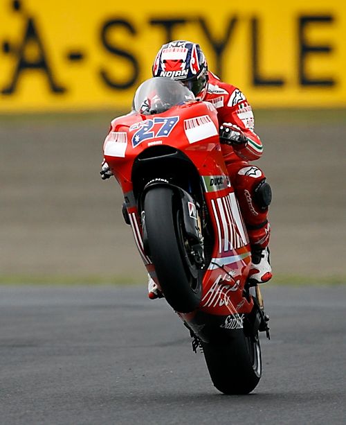 ZÁŘÍ - Mistrem světa v MotoGP se stal Australan Casey Stoner. Na obrázku slaví titul na cílové rovince jízdou po zadním kole. | Foto: Reuters