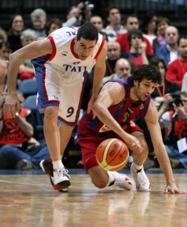 Sergi Vidal z Tau Ceramiky (v bílém) bojuje o míč s barcelonským Gianlucou Basilem. | Foto: Reuters