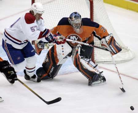 Brankář New Yorku Islanders goalie Rick DiPietro chtá střelu centra Montrealu Canadiens Gartha Murrayho. | Foto: Reuters