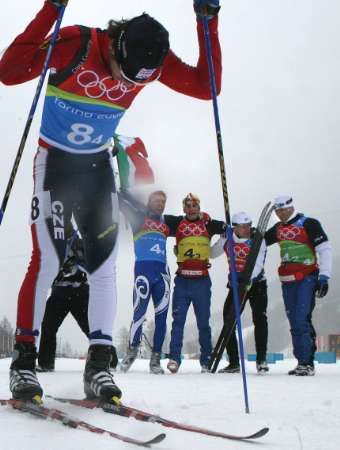 Vyčerpaný finišmen české štafety Dušan Kožíšek v cíli, za ním se radují zlatí Italové. | Foto: Reuters