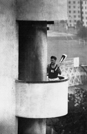 Finský sportovec běží na atletickém stadionu s olympijskou pochodní po schodech věže, na jejímž vršku bylo umístěno olympijské ohniště. Záběr z letních olympijských her v roce 1952 v Helsinkách. | Foto: Profimedia