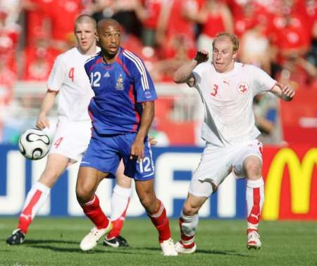 Francouz Thierry Henry (uprostřed) se snaží rozehrát. Za ním dobíhá švýcarský fotbalista Ludovic Magnin. | Foto: Reuters