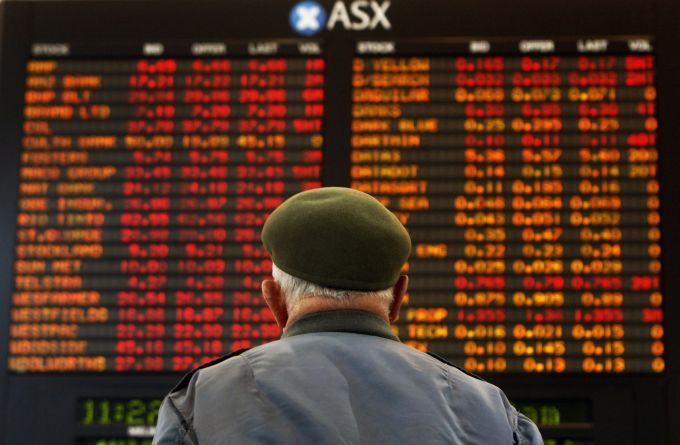 Muž sleduje panel s vývojem akcií na burze v australském Melbourne | Foto: Reuters