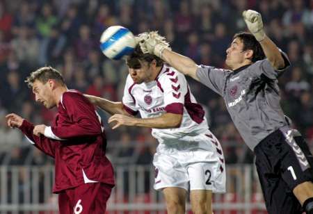 Gólman Hearts Craig Gordon vyboxovává míč před spoluhráčem Robbie Nielsonem (v bílém) a Janem Šimákem ze Sparty. | Foto: Reuters