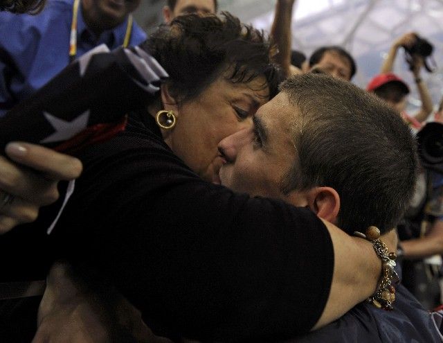 Michael Phelps v objetí se svou dojatou maminkou. | Foto: Reuters