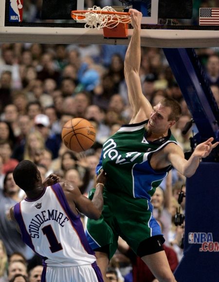 Hvězda Dallasu Dirk Nowitzki smečuje přes Amare Stoudemirea z Phoenix Suns. | Foto: Reuters