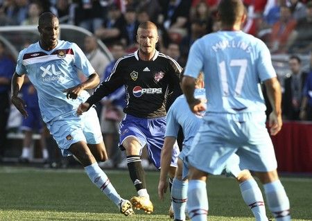 David Beckham v obležení hráčů West Hamu. | Foto: Reuters