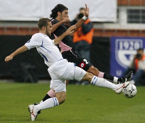 Jan Kysela (v bílém) z Kladna bojuje o míč s Cristianem Zaccardem z Palerma v prvním kole Poháru UEFA. | Foto: Reuters