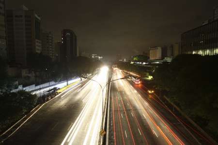 Auta míjící tmavé budovy během výpadku elektrického proudu v Sao Paulu | Foto: Reuters