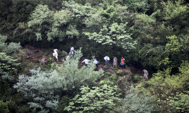 Záchranáři spěchají k místu neštěstí, které je však přístupné jen po špatně schůdných kopcovitých cestách. | Foto: Reuters