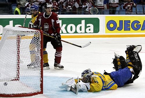 Ukrajinský gólman Vadim Seliverstov marsné stíhá puk, sledují jej Lotyš Martins Cipulis (v červeném) a Vitalij Ljutkevič. | Foto: Reuters