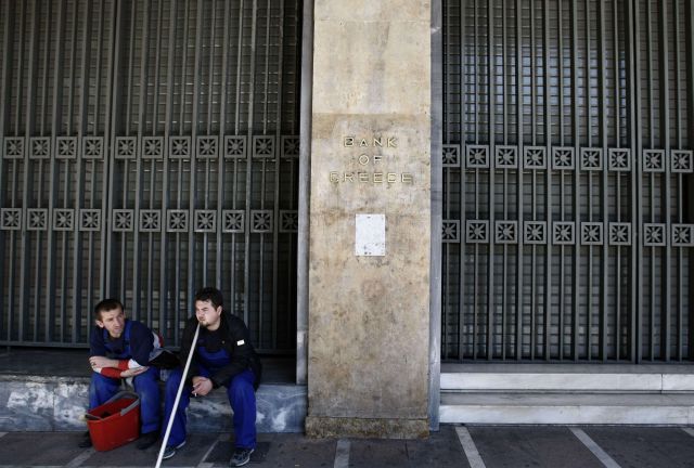 Pracovníci úklidové čety odpočívají před budovou řecké centrální banky. | Foto: Reuters