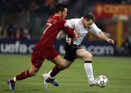 Marco Cassetti (vlevo) z AS Řím a Wayne Rooney z Manchesteru United v souboji ve čtvrtfinále Ligy mistrů. | Foto: Reuters