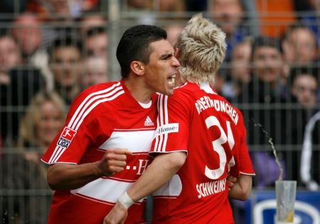 Lucio a Schweinsteiger slaví gól v síti Bochumi v zápase německé Bundesligy. | Foto: Reuters