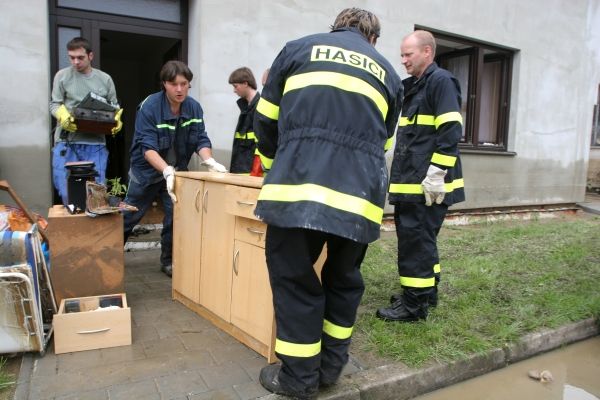 "Kontejnery už jsou plné, chybějí pytle na odpadky. Nestíhají to odvážet," naznačil jeden z hasičů, že voda 35 domů jedné jediné ulice naprosto zaskočila a škody pro místní rodiny budou velké. | Foto: Karel Toman