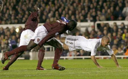 Ronaldo z Realu Madrid (v bímém) padá na zem, hrčí Arsenalu Emmanuel Eboue (vlevo) a Kolo Toure dělají, že za nic nemohou. | Foto: Reuters