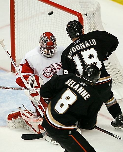 Anaheimský Andy McDonald sleduje gólovou střelu svého spoluhráče Teemu Selänneho do sítě Dominika Haška z Detroitu. | Foto: Reuters