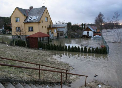 Většina domů u řeky měla večer zatopené zahrady. "Lužnice je nivní řeka, teče rovinou, tady nám nějaké hráze z pytlů s pískem nepomohou," říká starosta František Chramosta. | Foto: Aktuálně.cz, Ondřej Besperát