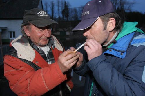 Soused Oldřich Pelikán připaluje cigaretu starostovi Klenovic Luboši Turínovi, který záchrannou akci pomáhal zorganizovat. Minulé dny i noci strávil před domem Markových mnoho hodin. | Foto: Ondřej Besperát, Aktuálně.cz