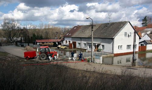 Markovi žijí v osadě Ovčín u Klenovic v těsné blízkosti Lužnice (hladina prosvítá vlevo nahoře), jejíž hladina je v současnosti téměř o metr výše než domy. | Foto: Ondřej Besperát, Aktuálně.cz