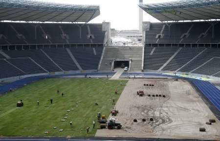 Dělníci pokládají nový trávník na berlínský Olympijský stadion, který bude hostit fotbalové MS. | Foto: Reuters