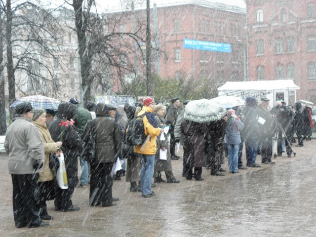 Nehledě na špatné počasí lidé stojí frontu, aby přečetli jména popravených. | Foto: Jiří Just