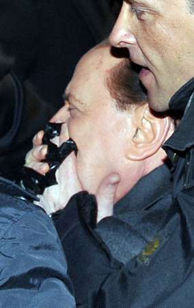 Podle svědků se Berlusconi po ráně svezl k zemi. | Foto: Reuters