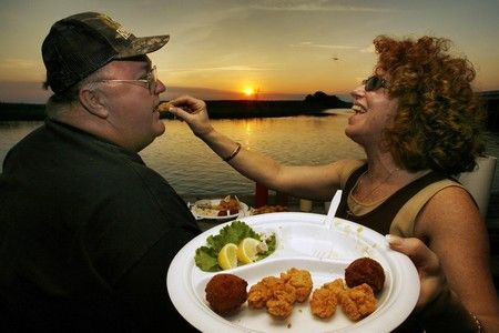 Bill James a Sonya Rogers z Ohia si rádi během západu slunce na terase restaurace v Cocoa na Floridě pochutnají na krokodýlí pochoutce s názvem "Gator Bites" | Foto: REUTERS/Hans Deryk