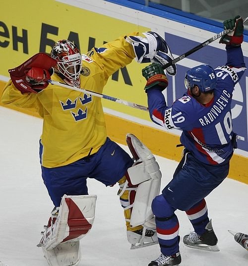 Švédský gólman Johan Bäcklund se za svojí brankou střetl s Branko Radivojevičem ze Slovenska. | Foto: Reuters