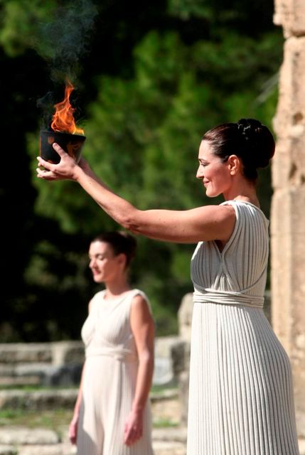 Představitelka hlavní kněžky herečka Naflpitou s miskou s planoucím olympijským ohněm. | Foto: Reuters