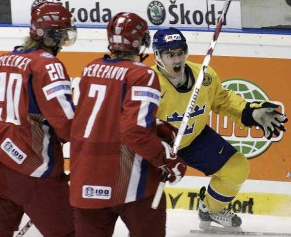 Alexej Čerepanov (uprostřed) přihlíží s Jakovem Selezněvem radosti švédského střelce Mikaela Bäcklunda v lednovém semifinále MS20 v Pardubicích. | Foto: Zuzana Hronová, Reuters