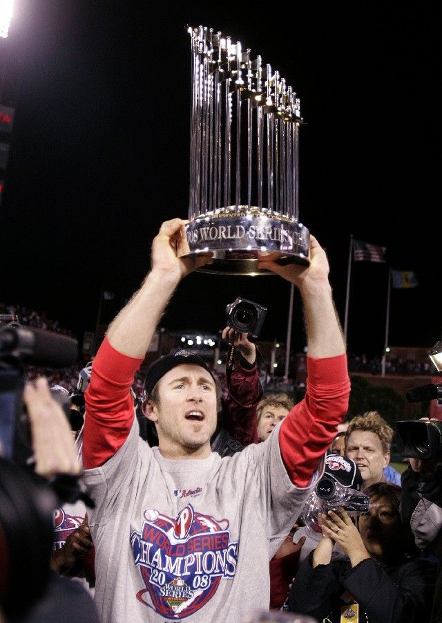 Baseballista Philadelphie Chase Utley drží trofej pro vítěze Světové série po vítězství nad Tampou Bay. | Foto: Reuters