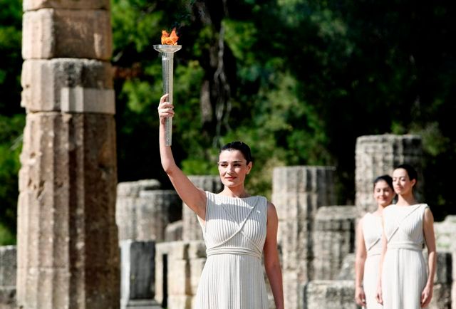 Představitelka hlavní kněžky Naflpitou s planoucím olympijským ohněm. | Foto: Reuters