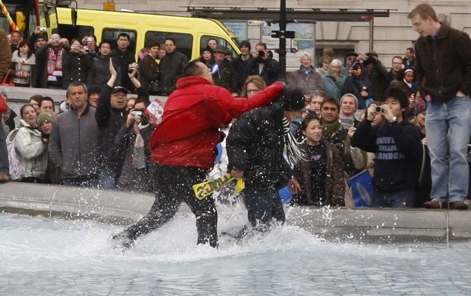 Ve fontáně na Trafalgar Square došlo i na pěsti. Zde si "to rozdávají" jeden pročínský a jeden protičínský protestující. | Foto: Reuters