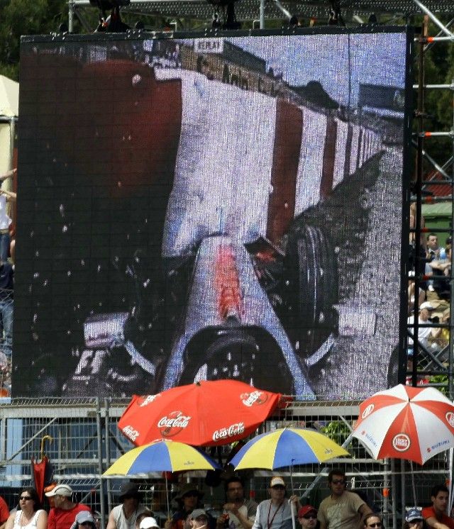 Španělsko - Diváci při VC Španělska sledují záběry Kovalainenovy hrozivě vyhlížející nehody. | Foto: Reuters