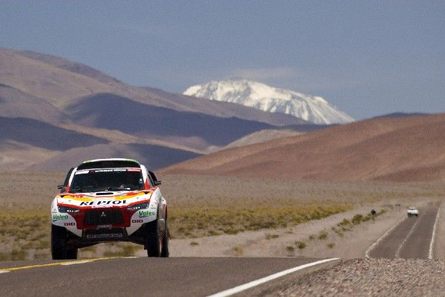 Letošní Rallye Dakar přináší kvůli rušení a zkracování etap až příliš neměřených přesunů po silnicích. S Andami v zádech upaluje po asfaltce Španěl Joan Roma se svým Mitsubishi. | Foto: Reuters