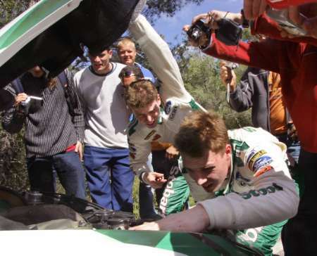 Soutěžní pilot Jari-Matti Latvala (vpravo) a jeho spolujezdec Miikka Anttila (za ním si prohlížejí moto svého fordu. | Foto: Reuters