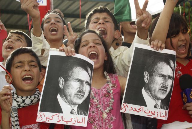 Palestinské děti v Ammánu drželi na protestní demonstraci fotografie Bushe v "hitlerovské úpravě." | Foto: Reuters