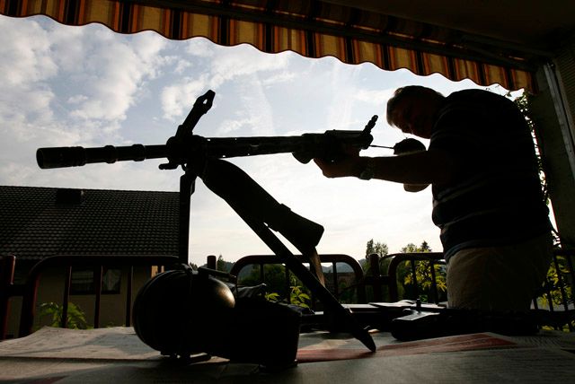 To není záběr z Iráku, ale ze Švýcarska. Muž v Lützelflühu ukazuje reportérům své vojenské vybavení... schovává ho ve sklepě. | Foto: Reuters