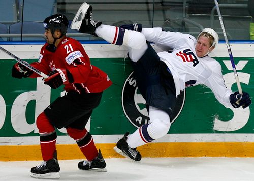 Američan Matt Green (v bílém) padá po kontaktu s Jamalem Mayersem z Kanady. | Foto: Reuters