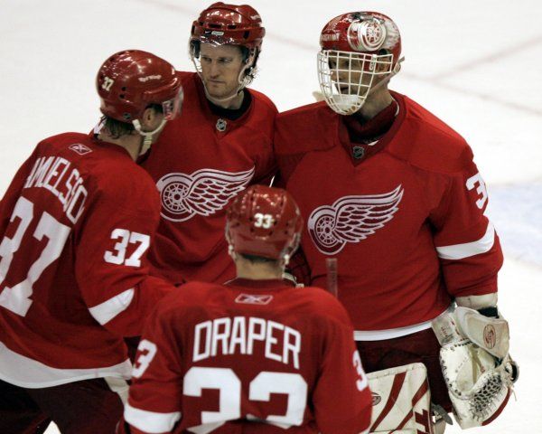 Brankáři Dominiku Haškovi gratulují k vychytané nule spoluhráči Niklas Kronwall, Mikael Samuelsson a Kris Draper. | Foto: Reuters