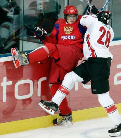 Ruský útočník Alexandr Ovečkin (vlevo) je u mantinuelu atakovaný Robynem Regehrem z Kanady. | Foto: Reuters