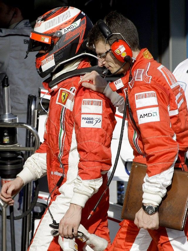 Finský pilot Ferrari Kimi Räikkönen (vlevo) kráčí v doprovodu mechanika své stáje do depa po neúspěšné VC Austrálie. | Foto: Reuters