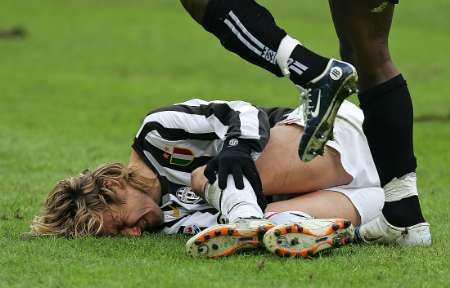 Pavel Nedvěd z Juventusu Turín leží na trávníku po jednom z nevybíravých zákroků soupeře. Takto jej v ligovém utkání s Udinese skolil Ali Muntari. | Foto: Reuters